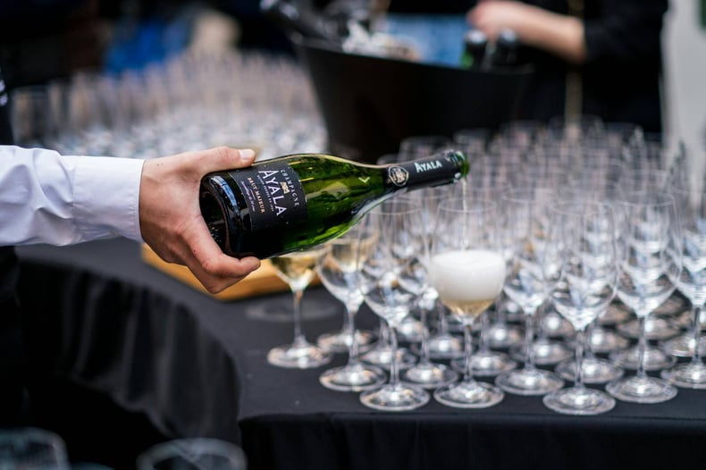 A Person Pouring Champagne into Glasses