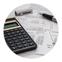 a calculator, a paper with writings and a pen