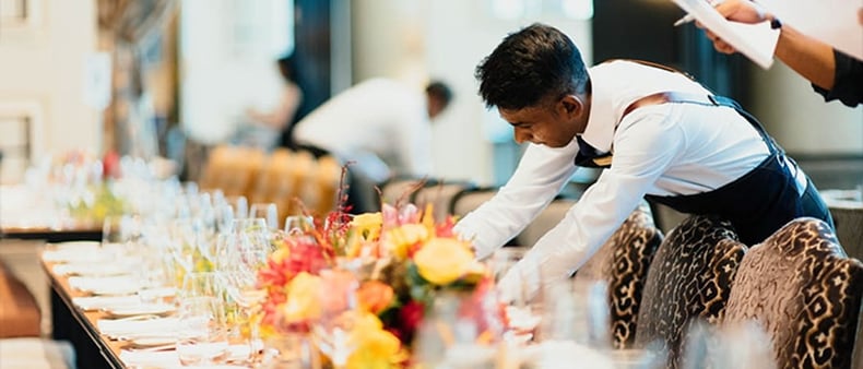 a-man-setting-a-table-at-an-event