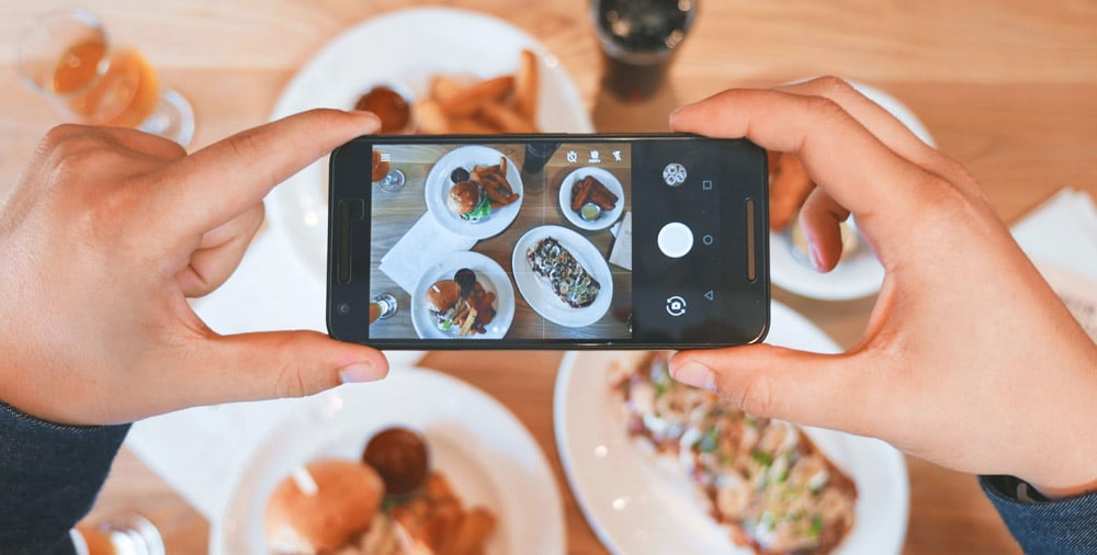 a-man-taking-a-photo-of-food