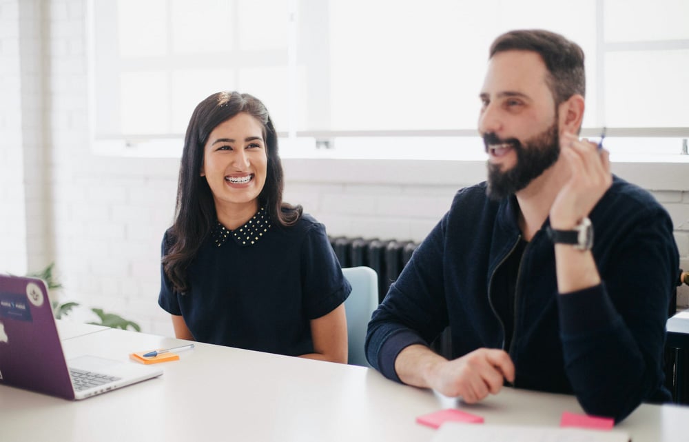 a-woman-laughing-with-a-man-in-the-office