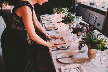 a woman doing table set up for an event