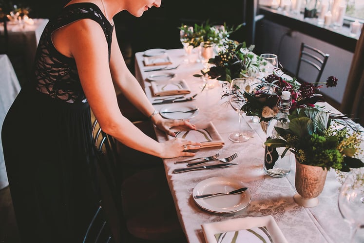 a picture of a woman setting up the table