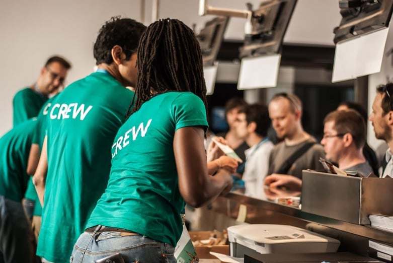 events crew wearing green t-shirt and customer buying tickets